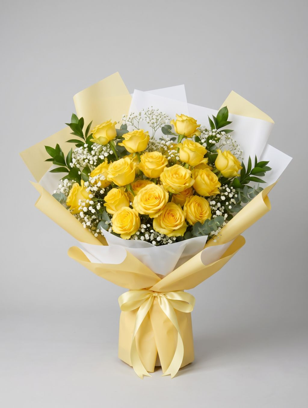 18 Yellow Roses Bouquet of eighteen yellow roses with baby’s breath, eucalyptus and greenery wrapped in yellow and white paper with a pale yellow satin ribbon