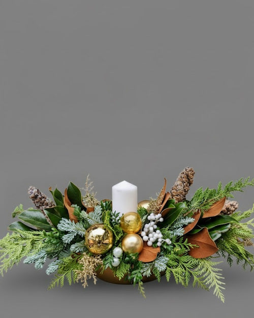 Forest Gold holiday arrangement with pine cones & evergreens on a modern table setting.