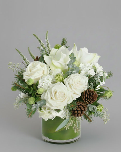 Winter Forest centerpiece with noble fir, pine cones, and berries on a rustic wooden table.