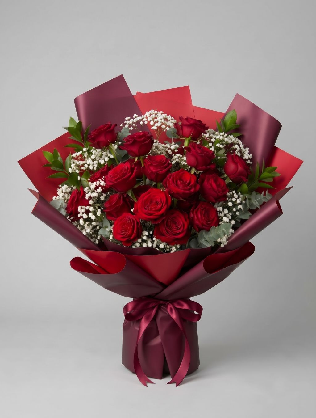 18 Red Roses Bouquet of eighteen red roses with baby’s breath, eucalyptus and greenery wrapped in red and burgundy paper with a burgundy satin ribbon
