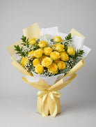 18 Yellow Roses Bouquet of eighteen yellow roses with baby’s breath, eucalyptus and greenery wrapped in yellow and white paper with a pale yellow satin ribbon