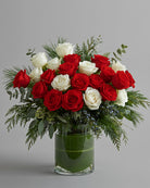 Bouquet of red and white roses in a clear vase on a gray background