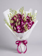 Pink Dendrobium Bouquet of magenta-pink dendrobium orchids with green buds wrapped in white paper with a fuchsia satin ribbon