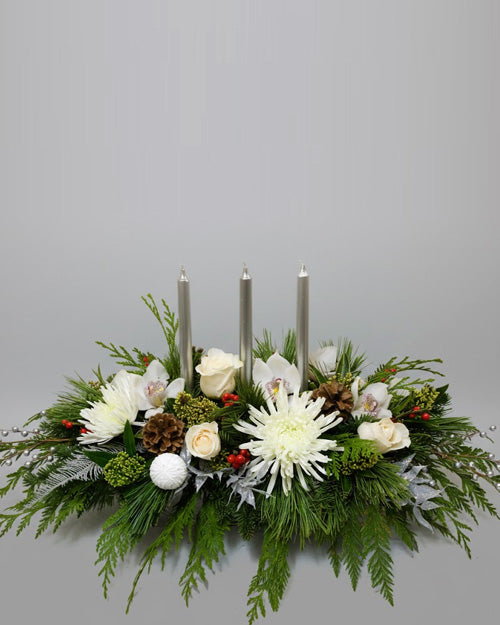 Sparkling Christmas Centerpiece with white roses, evergreen, and silver glittered accents.