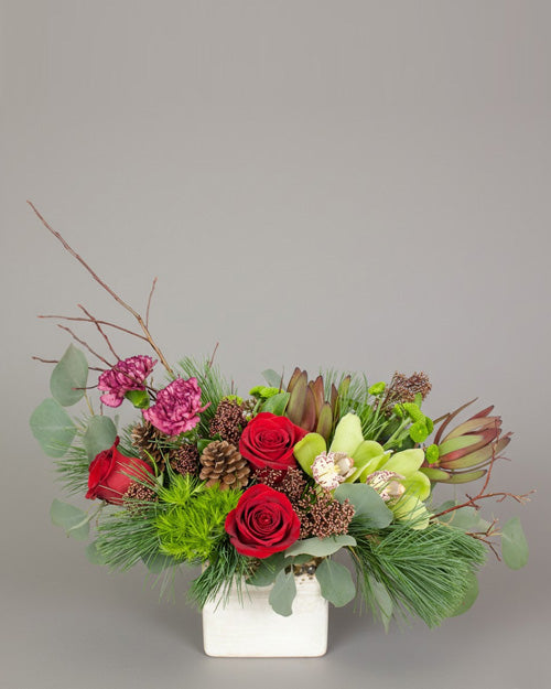 Spirit of the Season bouquet with red roses and green orchids as a festive holiday centerpiece.