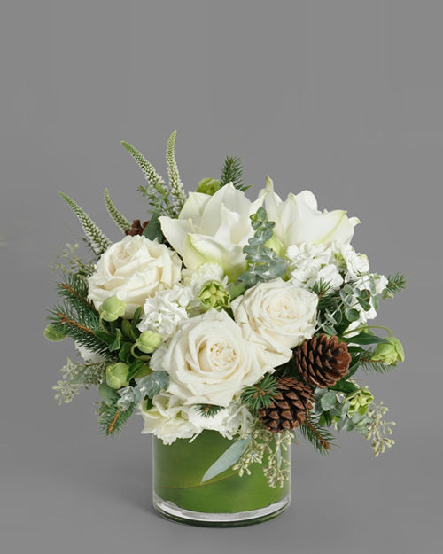 Winter Forest centerpiece with noble fir, pine cones, and berries on a rustic wooden table.