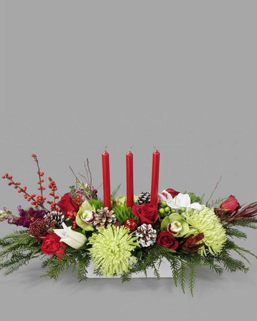 Floral arrangement with red candles on a gray background