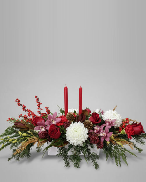 Floral arrangement with red candles on a gray background